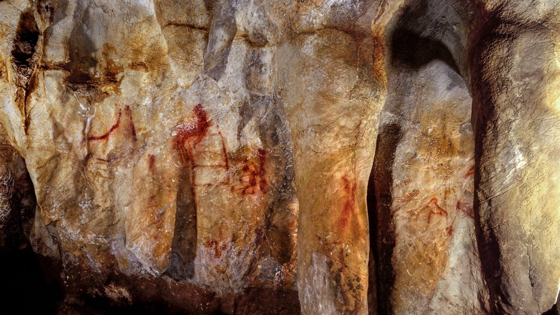 La Pasiega, sección C, pared de cueva con pinturas. Las líneas verticales y horizontales rojas  datan de 64.000 años, y fueron pintadas casi seguramente  por los neandertales.