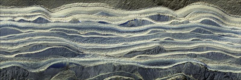 Esta imagen  muestra capas alternas de hielo y arena en un área donde quedan expuestas sobre la superficie de Marte. El agua helada es de color claro, mientras que la arena es azul oscuro. Imagen: NASA/JPL/University of Arizona