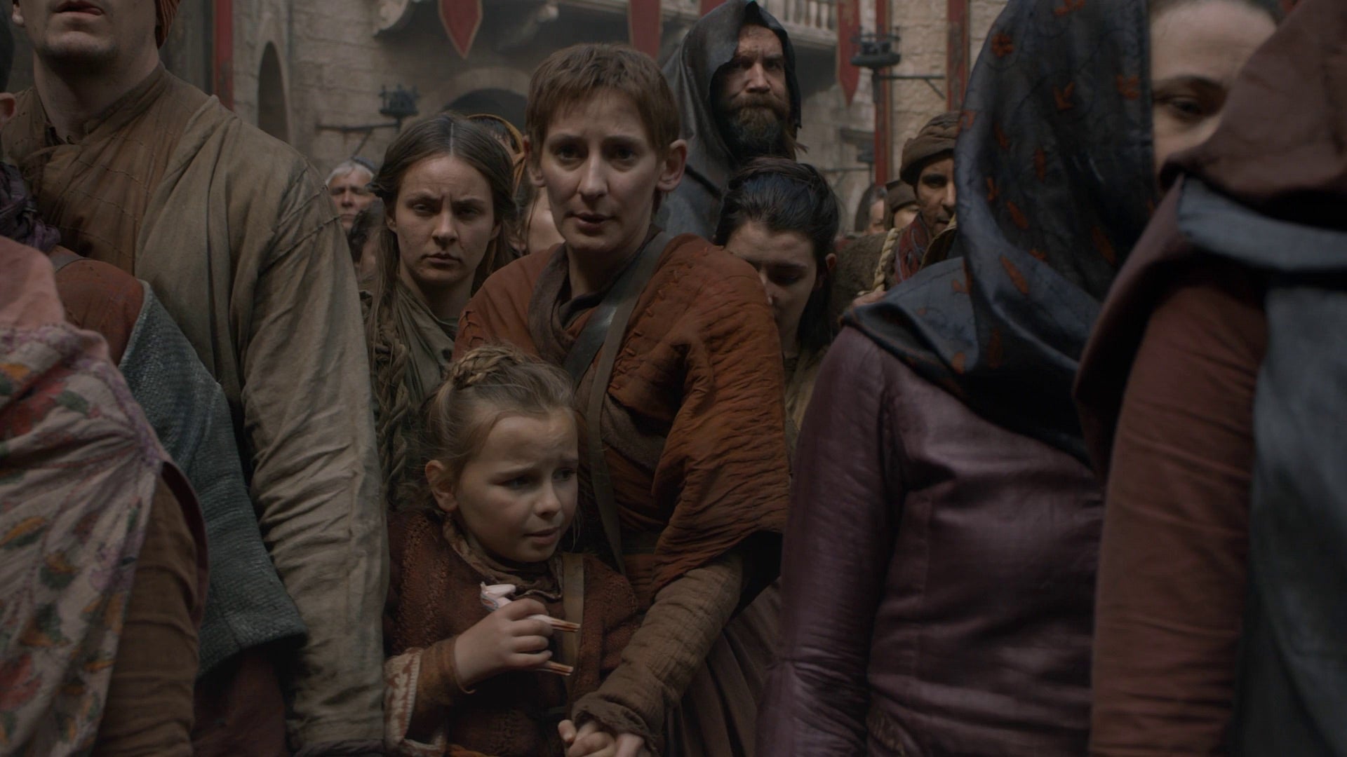 La niña lleva un caballo blanco en la mano