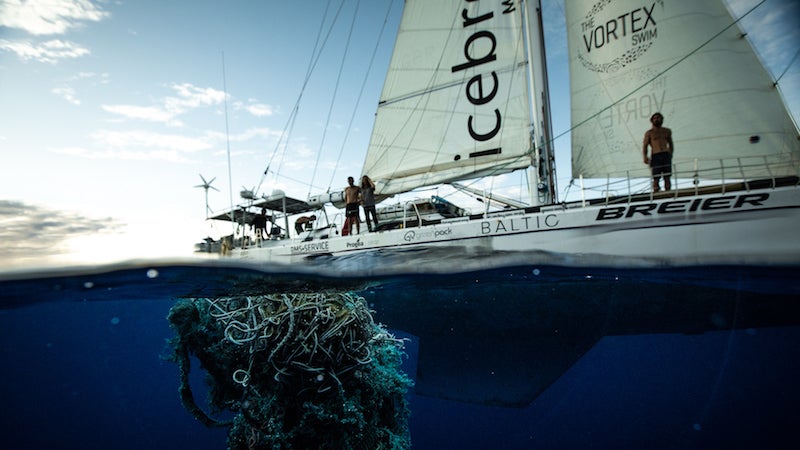 El equipo del Vortex Swim lanza una red para recoger plástico.