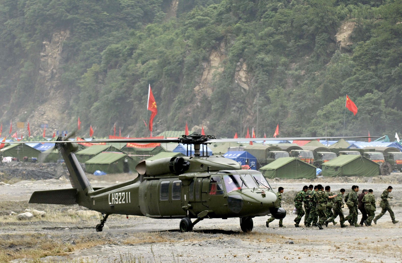 Tropas chinas transportan a un sobreviviente desde un helicóptero S-70 en un helipuerto improvisado en Yingxiu, provincia de Sichuan, suroeste de China, el 29 de mayo de 2008.