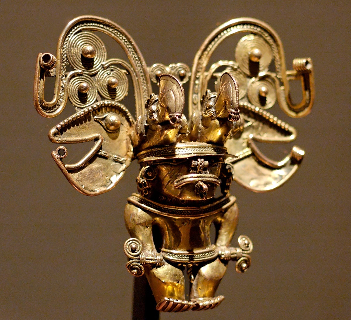 Colgante antropomorfo Tayrona, representando un chamán con dos cetros.