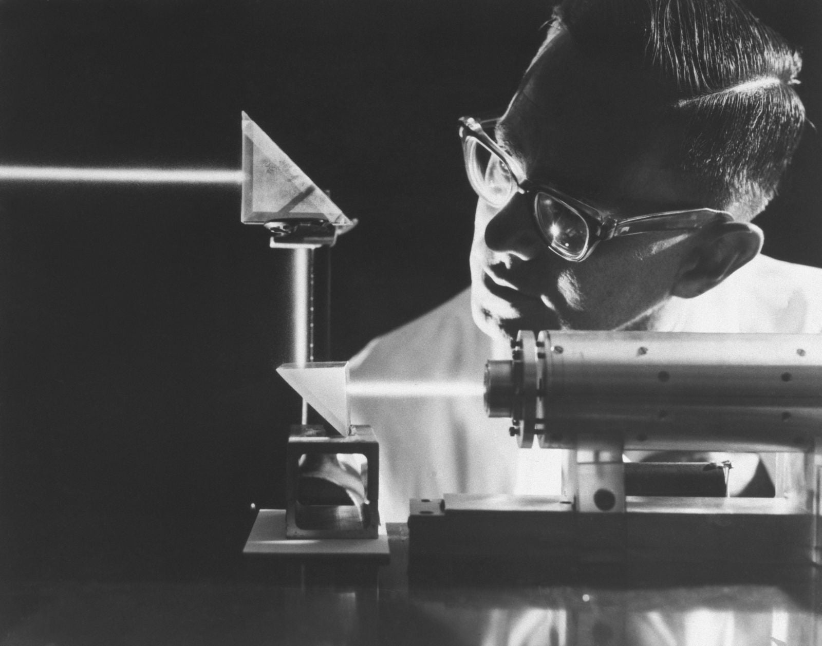 Photo: Un intenso rayo de luz láser de rubí penetra en prismas gemelos durante un experimento en la División de Autonetica de la Aviación de América del Norte, 1965. A pesar del brillo del rayo, las armas láser todavía estaban a medio siglo de la realidad