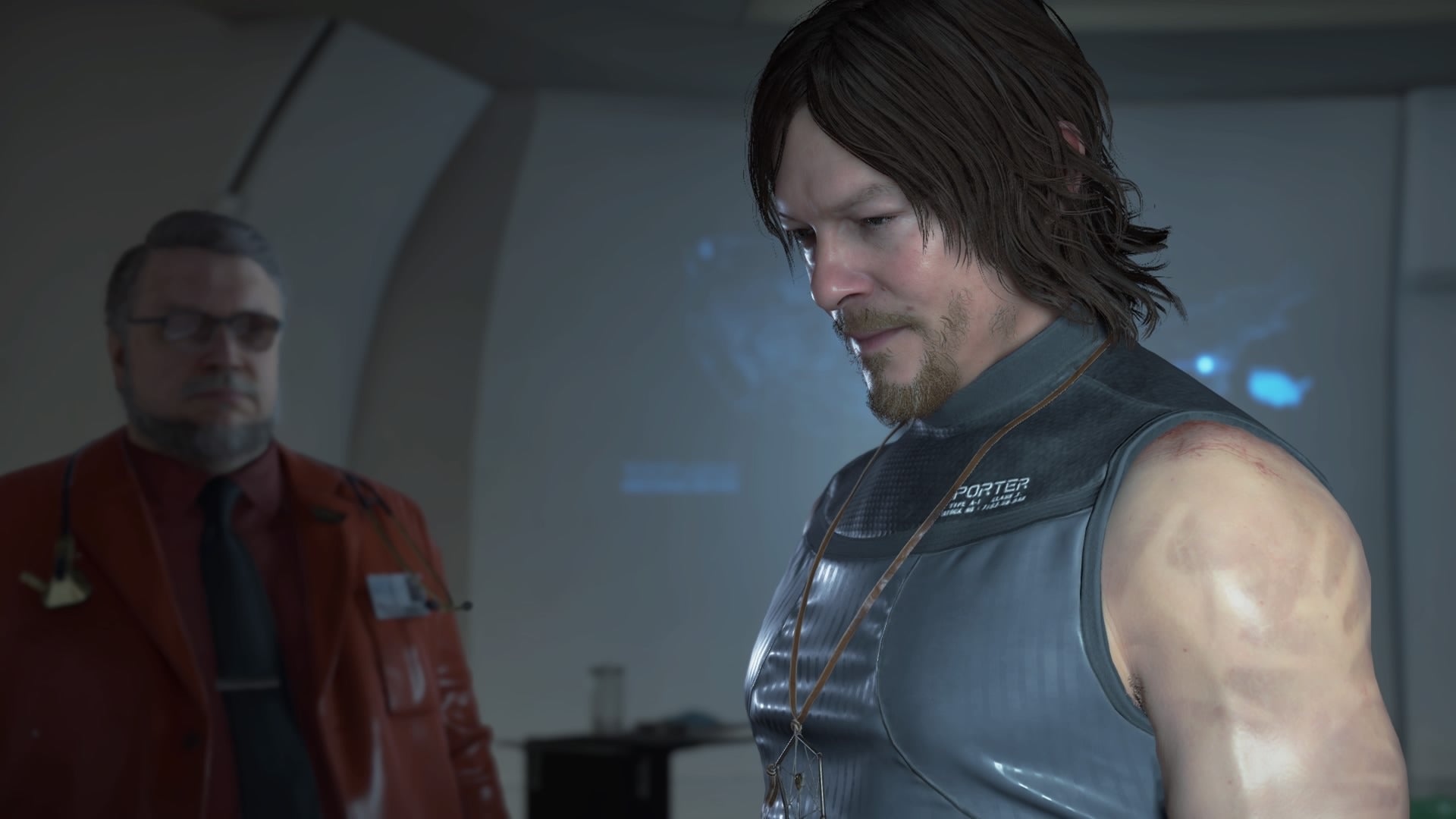 El nivel de detalle de los gráficos de Death Stranding es impresionante. En la imagen podemos ver a Sam, interpretado por Norman Reedus, y el personaje que luce como Guillermo del Toro.