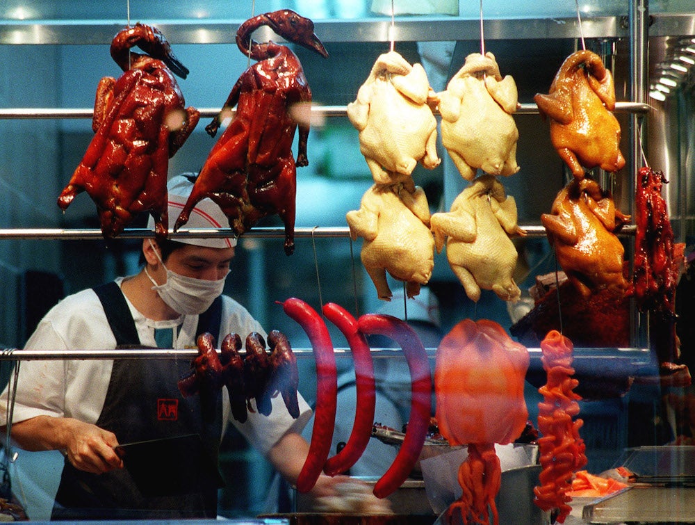 Image: Un trabajador de un restaurante usa una máscara quirúrgica en un intento de protegerse del SARS