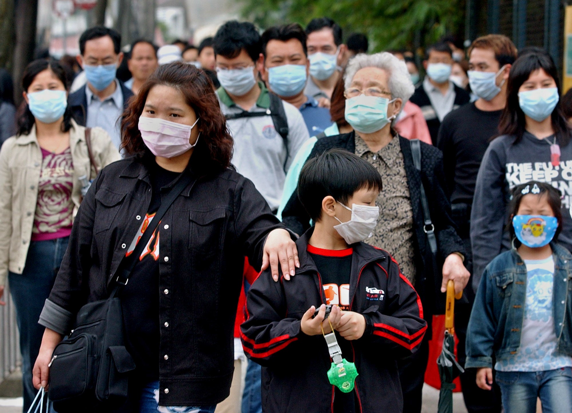 Image: Peatones esperan para cruzar una calle en Hong Kong el 15 de abril de 2003