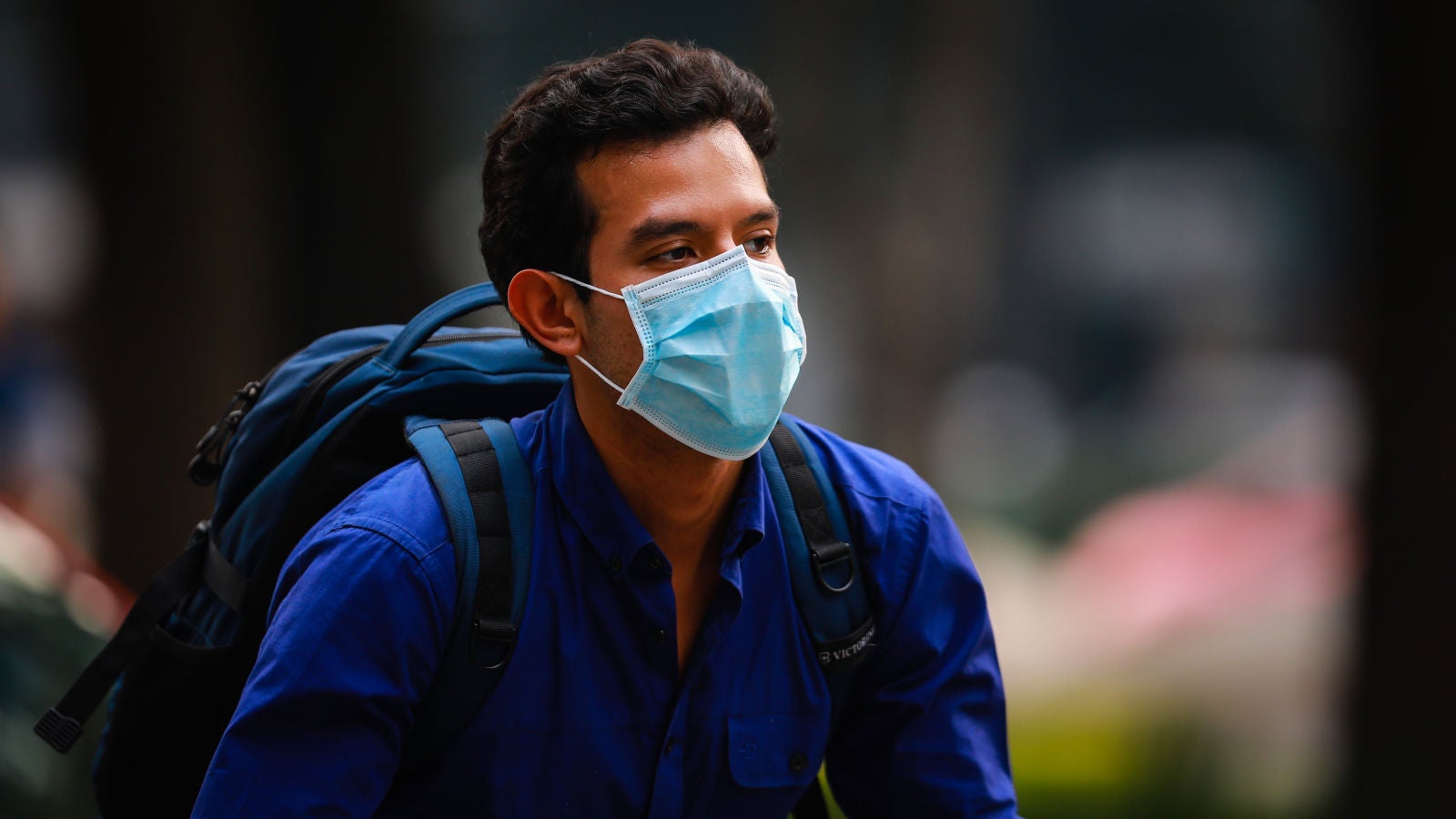 Un hombre, llevando una mascarilla quirúrgica por la calle.