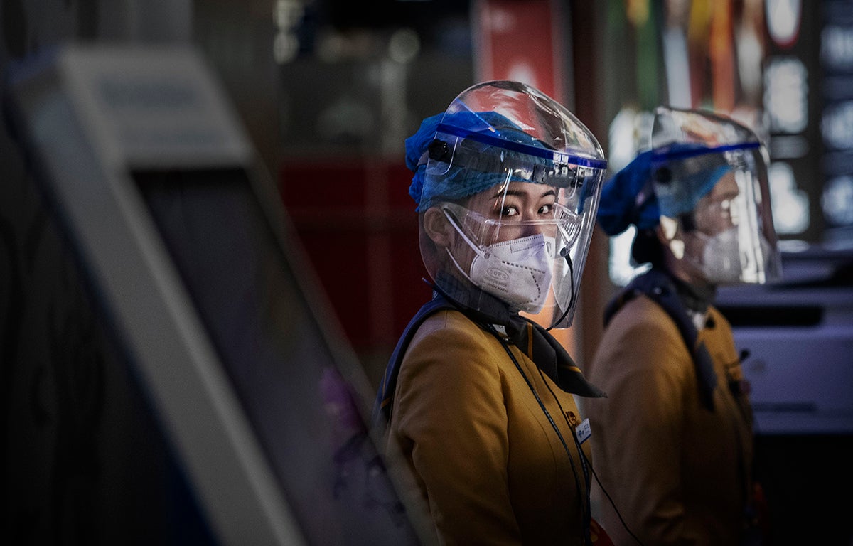 Personal de tierra del aeropuerto de Pekín con equipamiento contra el coronavirus en una foto de marzo de 2020.