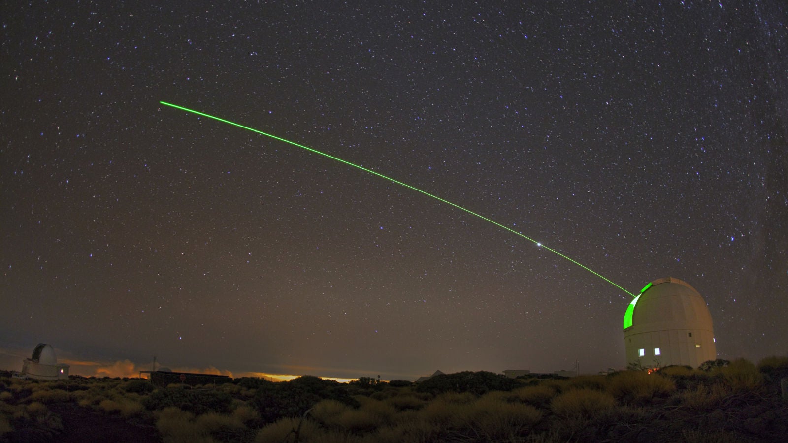 Un láser verde visible brilla desde la estación de tierra óptica (OGS) de la ESA.