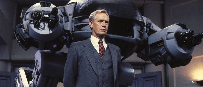 Dick Jones, interpretado por Ronny Cox, junto al ED-209.