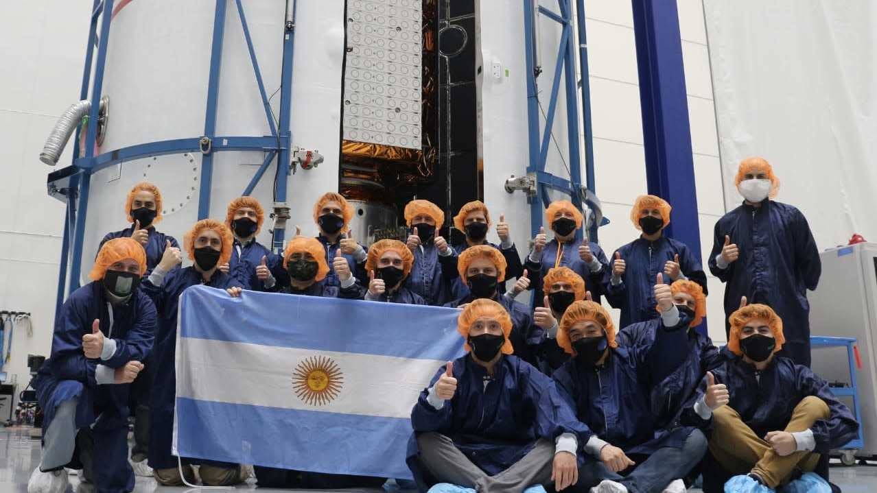 El satélite SAOCOM-1B en la cofia del lanzador Falcon 9 junto al equipo de CONAE