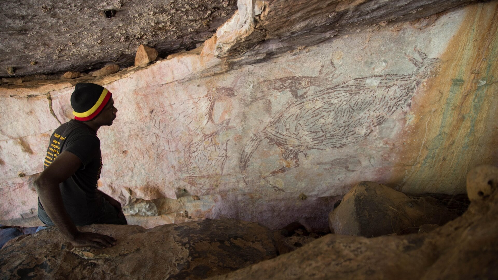 Ian Waina, un propietario tradicional, observando la pintura de un canguro de 17.300 años.