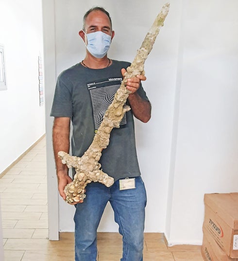 El buceador Shlomi Katzin blandiendo la espada que encontró