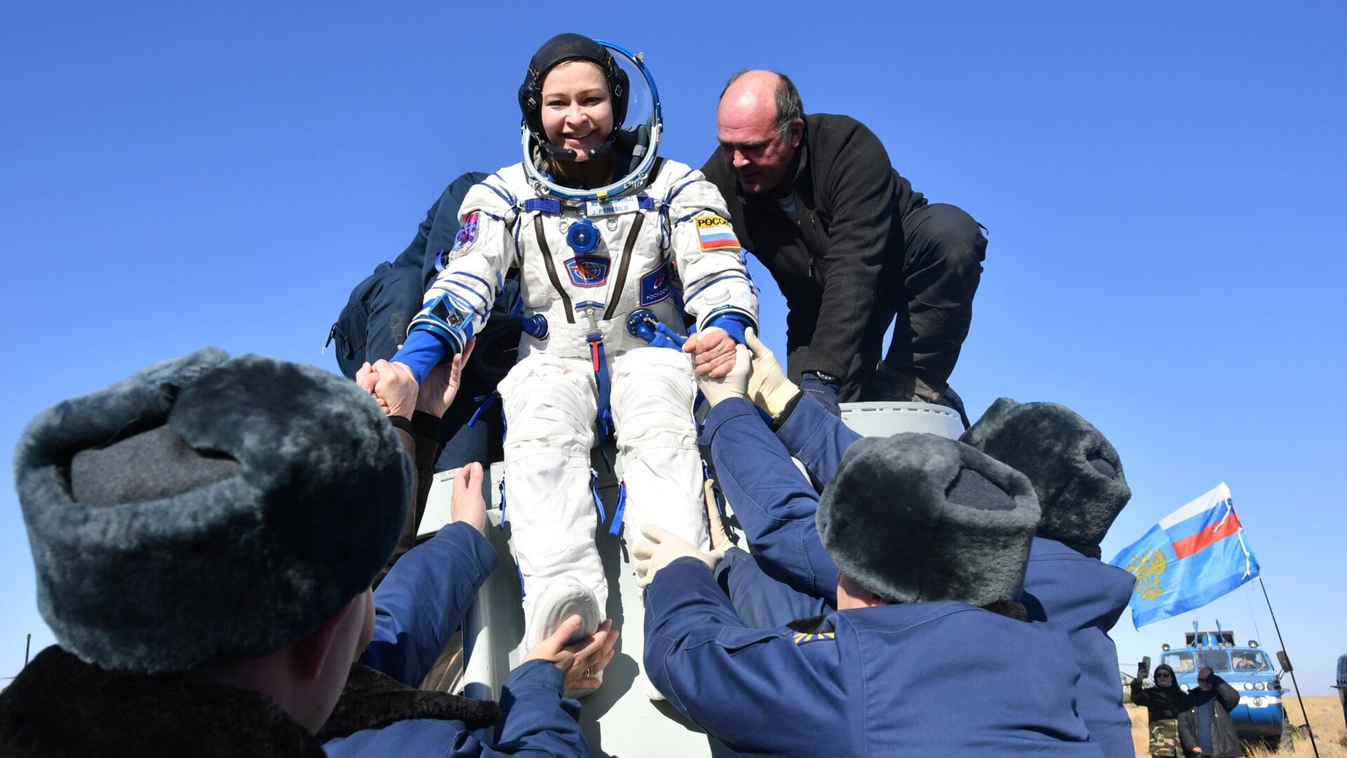 Los miembros del equipo de rescate de la agencia espacial rusa ayudan a la actriz Yulia Peresild a salir de la cápsula poco después del aterrizaje de la cápsula espacial rusa Soyuz MS-18.