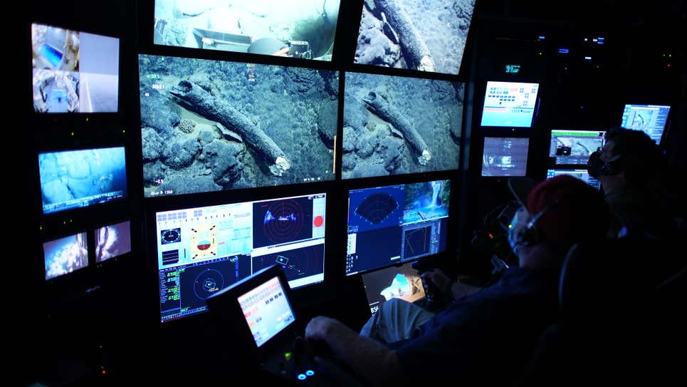 Randy Prickett (izquierda) pilota un ROV MBARI, mientras que el científico Steven Haddock (derecha) documenta el colmillo de mamut antes de la operación de recuperación.
