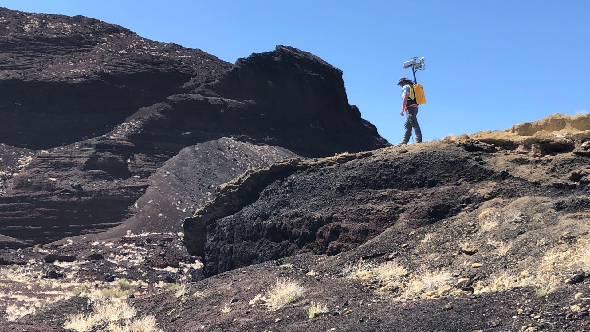 El científico planetario de la NASA Michael Zanetti probando la mochila en el campo volcánico Potrillo en Nuevo México.