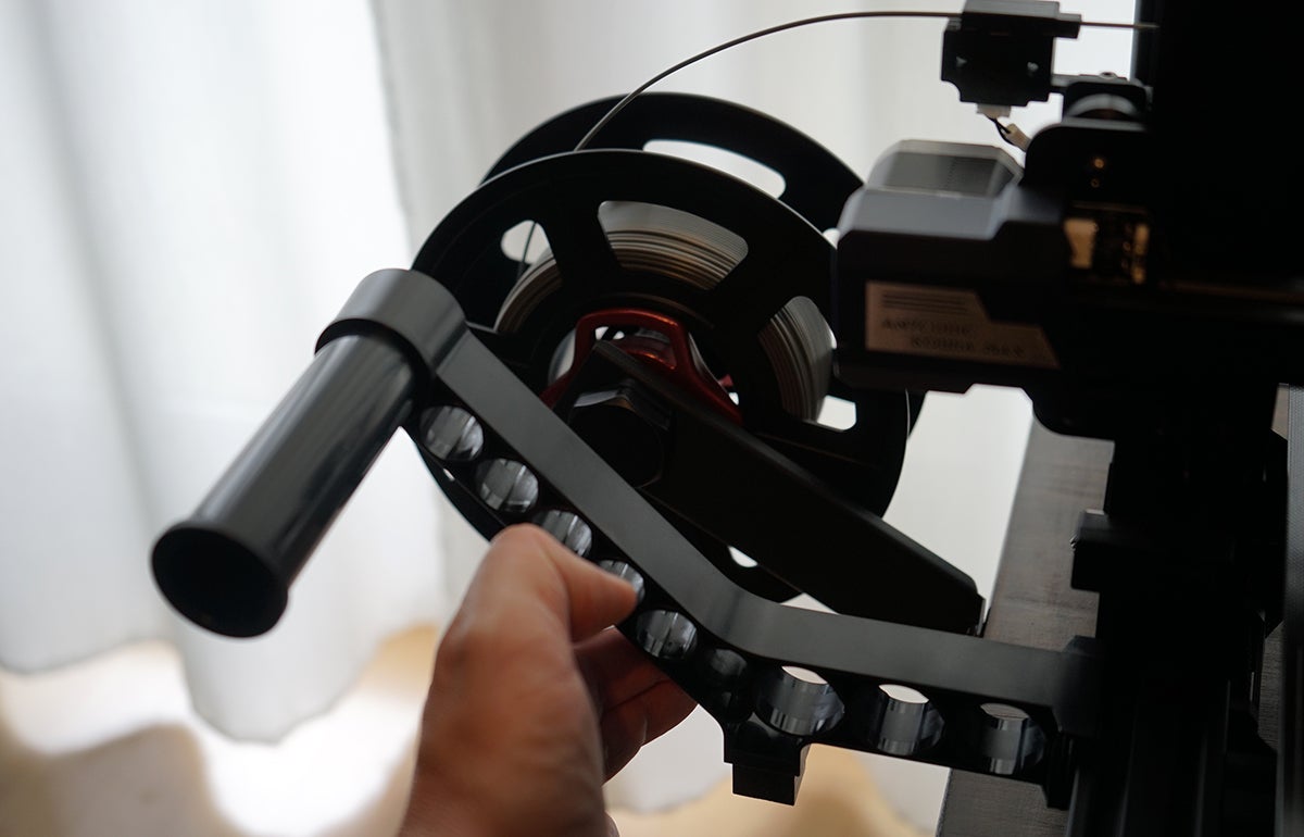 El soporte para los rollos de filamento sobresale bastante por un lateral. No me da la mesa.