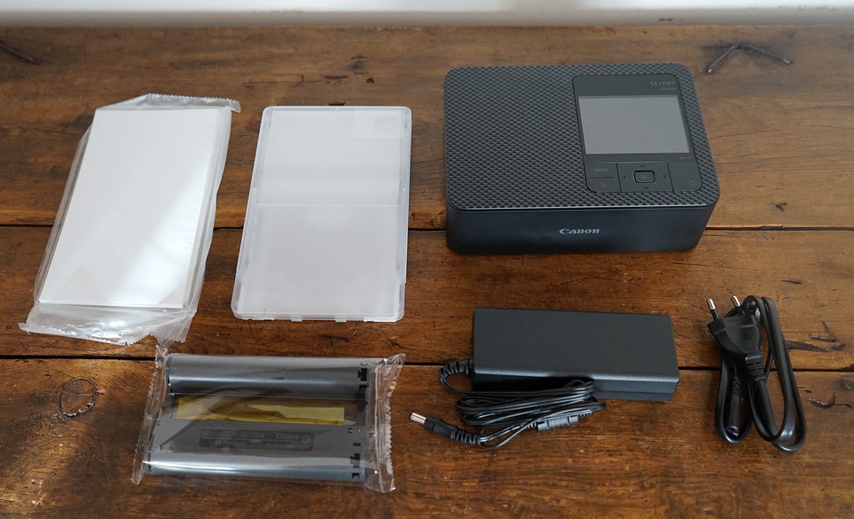 La CP15000 junto al contenido típico de un consumible: cartucho de tinta y 36 papeles fotográficos de alta calidad de 10x15.