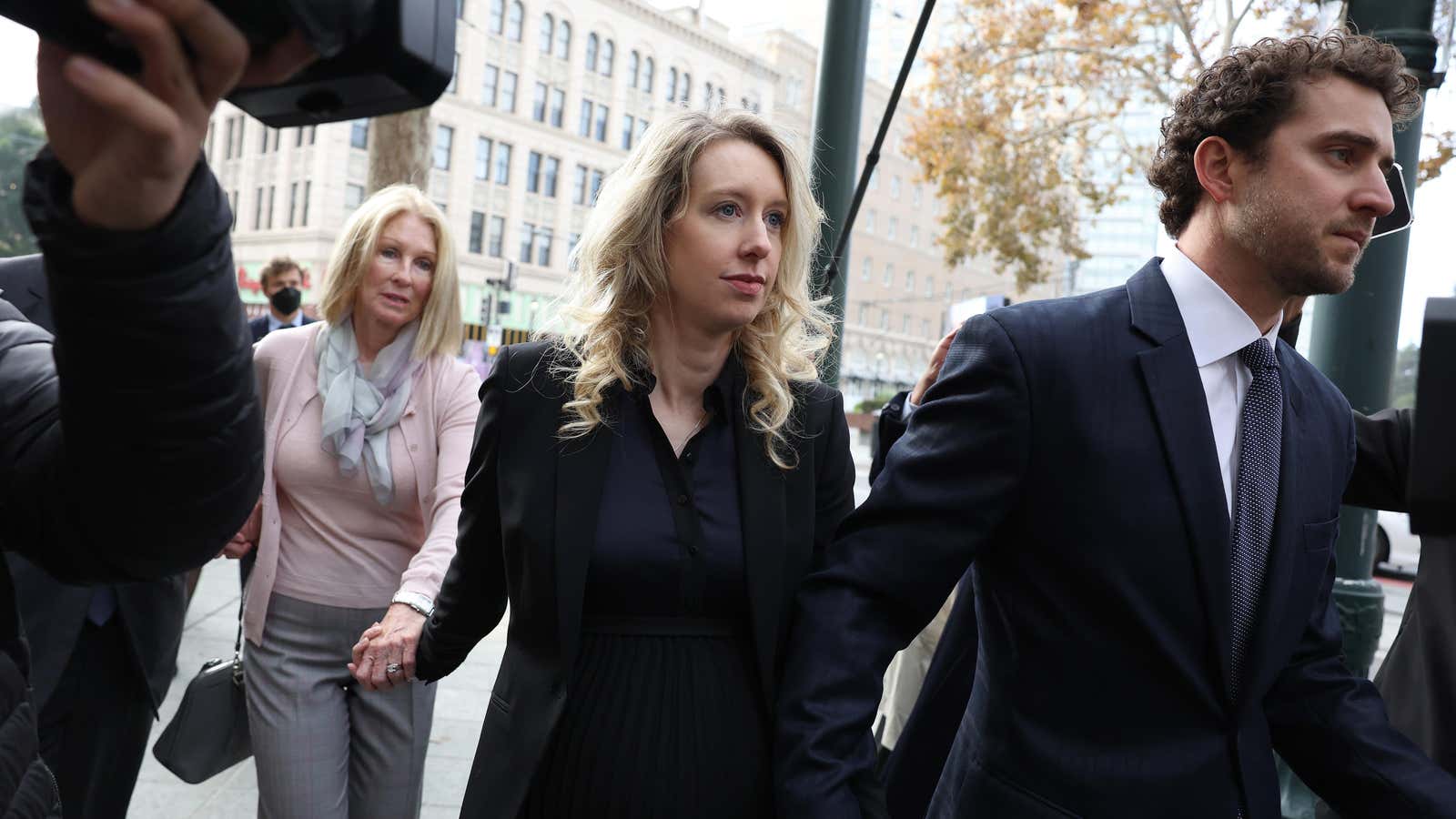 La directora ejecutiva de Theranos, Elizabeth Holmes, en el centro, entra a la corte rodeada por su madre, Noel Holmes, y su pareja, Billy Evans. Holmes fue sentenciado en el Tribunal Federal de San José el 18 de noviembre