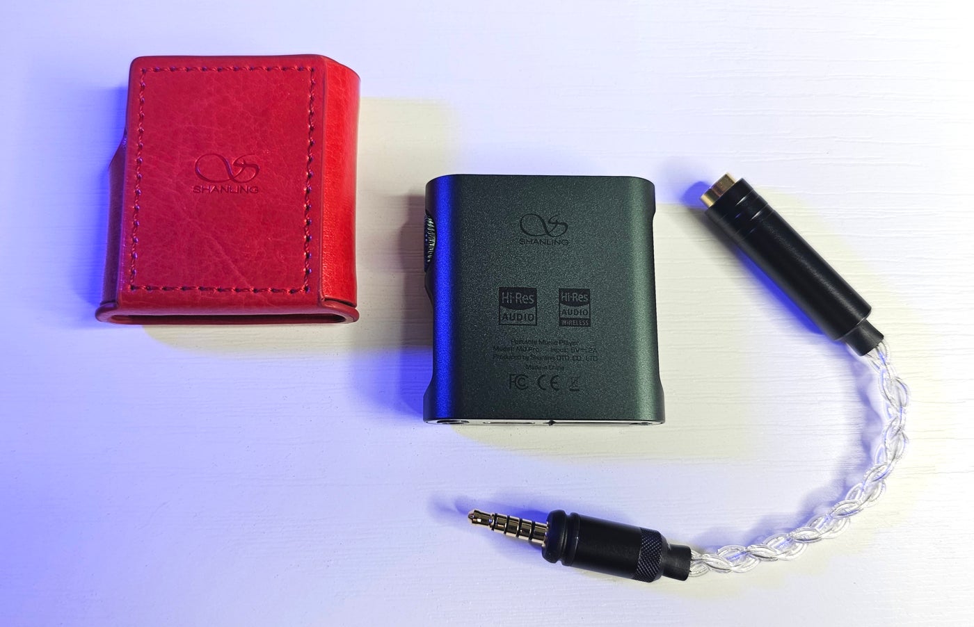 El M0 Pro junto a sus dos accesorios: una funda protectora y el cable adaptador de 3,5mm a 4,4mm balanceado (se venden por separado).