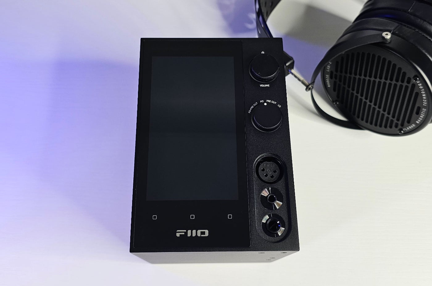 Pantalla de casi 5", puertos de auriculares, control de volumen y selector de salida.