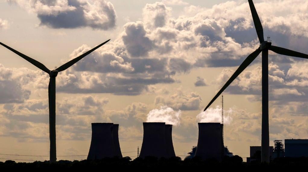 Las turbinas eólicas generan electricidad mientras la central eléctrica Drax en el fondo también genera electricidad el 29 de junio de 2023 en Selby, Inglaterra.
