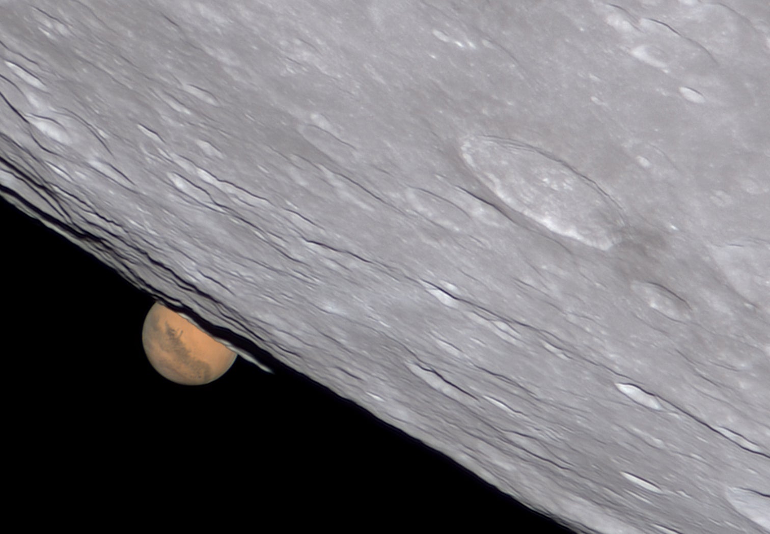 Marte asomando desde detrás de la Luna.