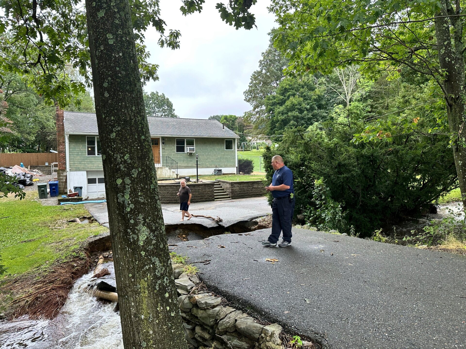 El propietario de la vivienda, John Schuller, evalúa los daños por inundación en la carretera que conduce a su casa en Leominster, Massachusetts, el 12 de septiembre de 2023.