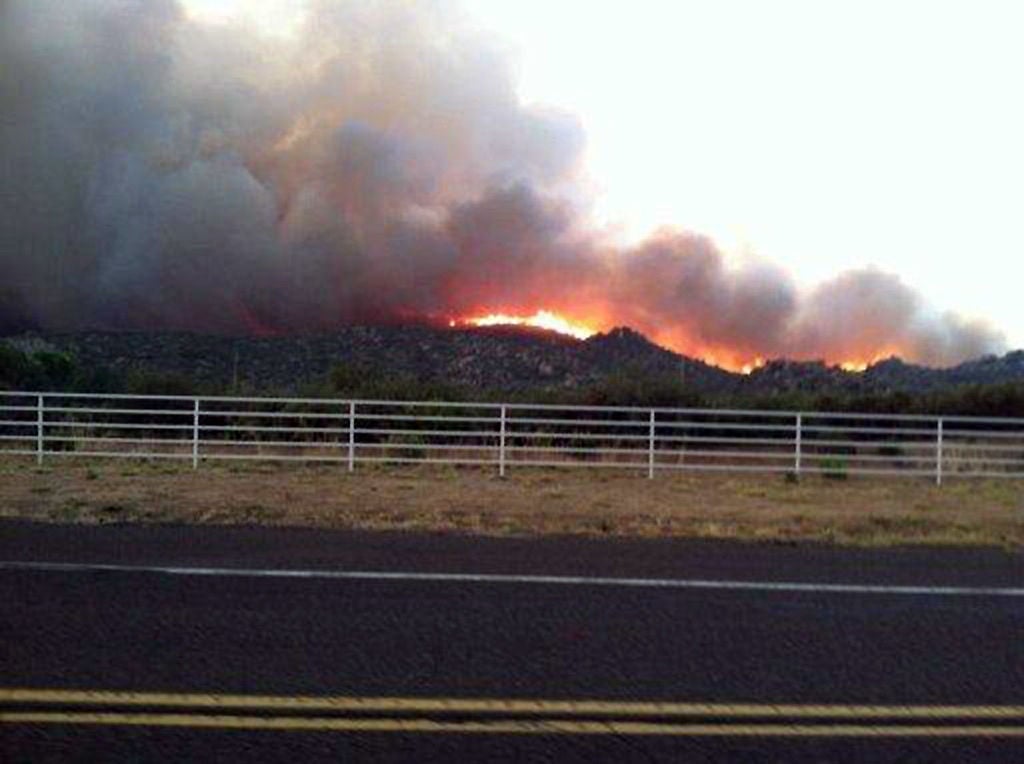 El incendio de Yarnell Hill arde en esta vista desde la autopista I-17, el 29 de junio de 2013, cerca de la ciudad de Yarnell, Arizona, a unas 80 millas  (128 km) al noroeste de Phoenix. 