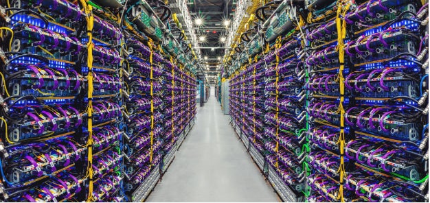 Una fila de supercomputadoras aceleradoras de  AI TPU v5p en un centro de datos de Google.