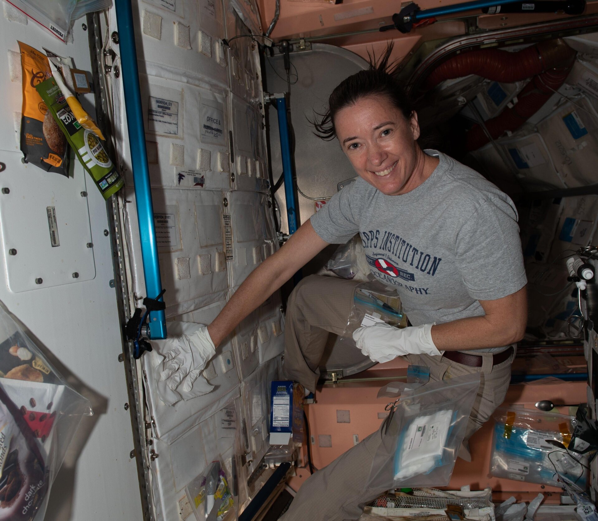 La astronauta de la NASA e ingeniera de vuelo de la Expedición 65 Megan McArthur recolecta una muestra de microorganismos presentes en la Estación Espacial Internacional en julio de 2021 para su análisis y seguimiento en el estudio Microbial Tracking-3.