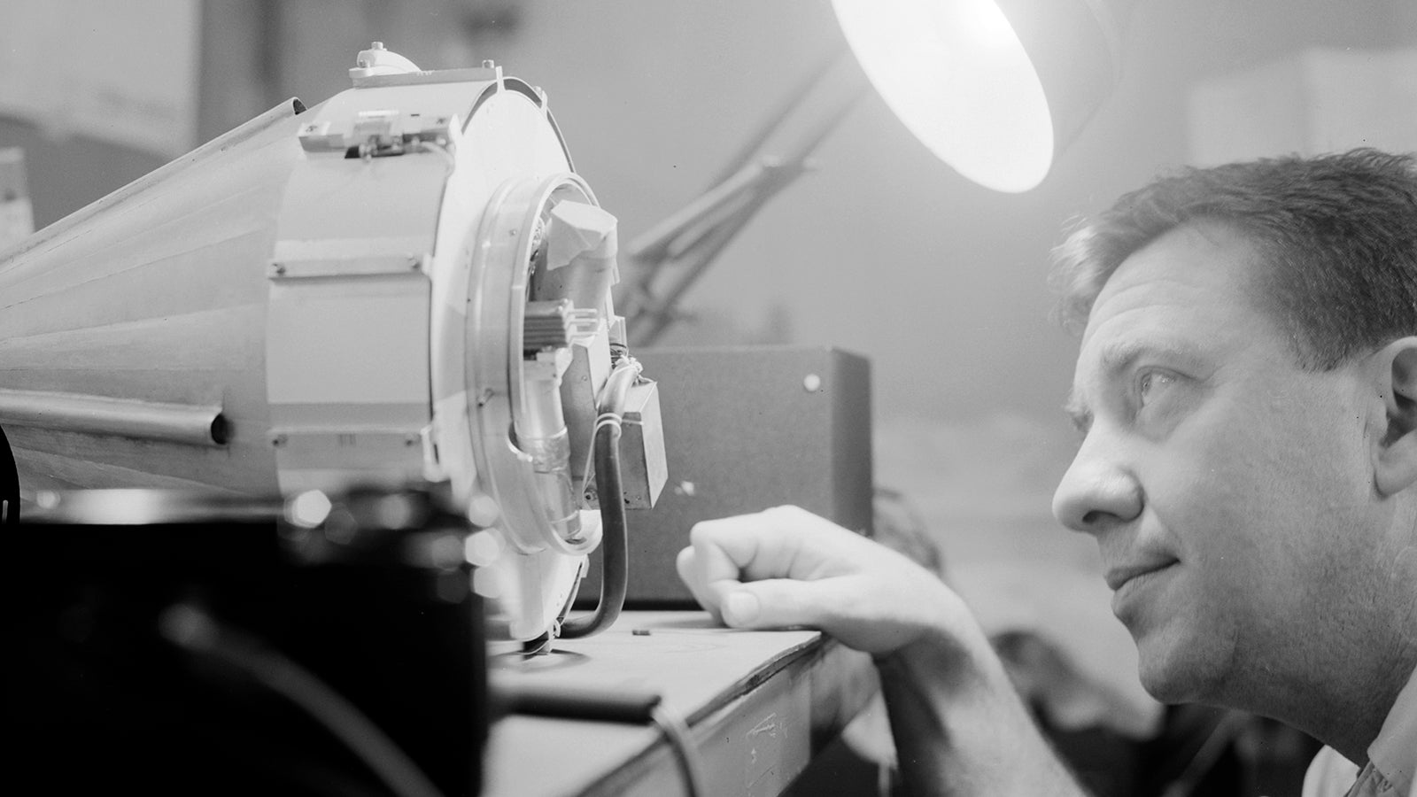 El científico James Van Allen inspecciona la sonda Pioneer 4 en forma de cono antes del lanzamiento. 