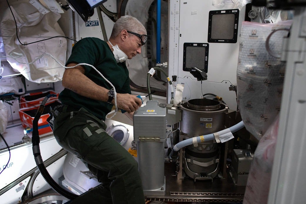El astronauta de la NASA Mark Vande Hei trabajando en un nuevo inodoro avanzado durante su instalación en 2021.