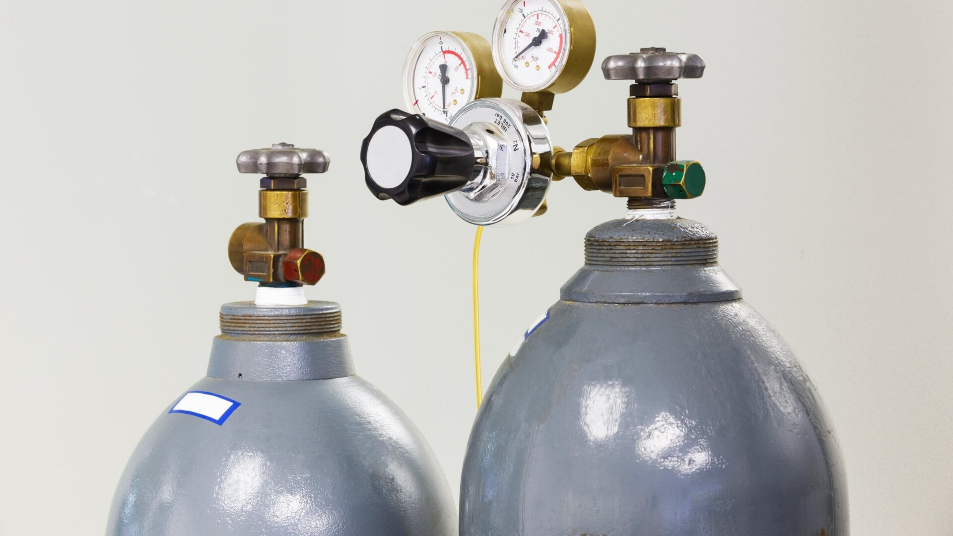 Un primer plano de los medidores y la válvula de un viejo cilindro de gas nitrógeno.