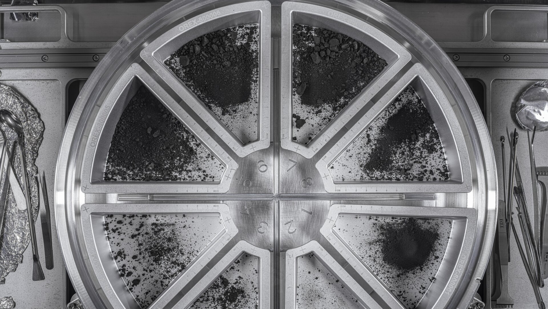 Una vista de ocho bandejas de muestras que contienen el material final del asteroide Bennu.