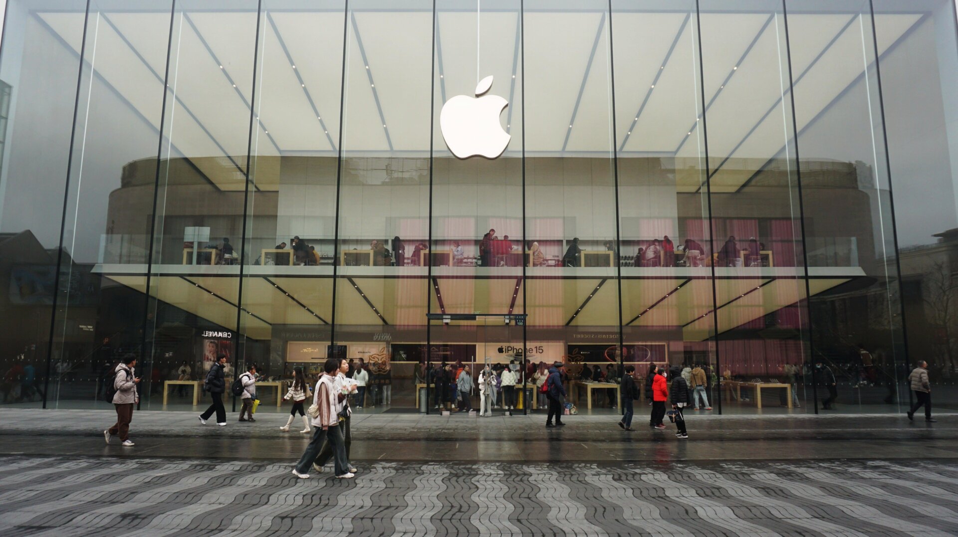 Fotografía de archivo de personas caminando frente a una tienda insignia de Apple en Hangzhou, provincia de Zhejiang, China, 20 de febrero de 2024.