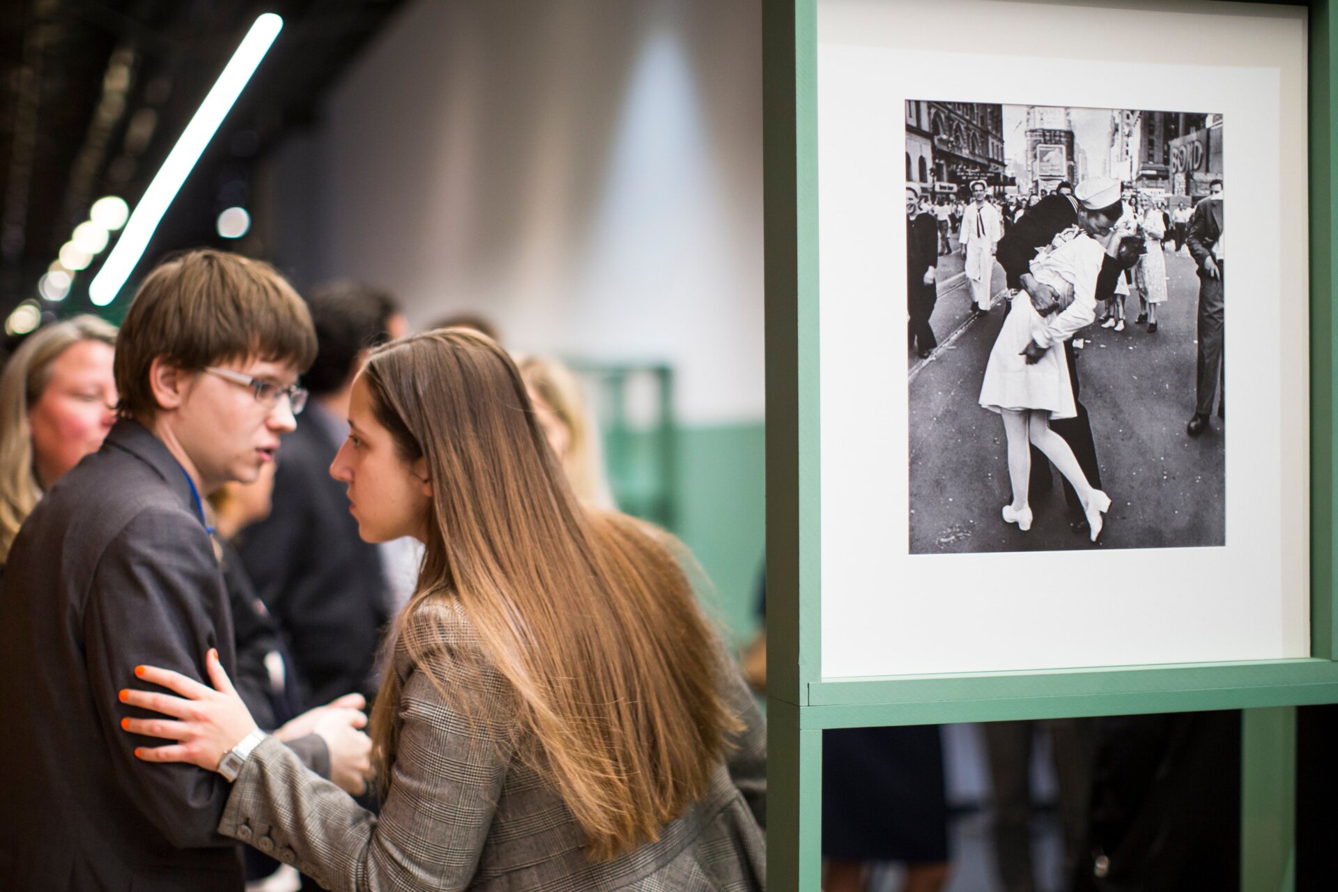 La gente habla junto a una famosa fotografía tomada por Alfred Eisenstaedt de un marinero besando a una enfermera en el Times Square de Nueva York en el VJ Day , a la derecha, mientras visitan la exposición de Vida El fotógrafo de revista Alfred Eisenstaedt en el Museo Judío y Centro de Tolerancia de Moscú, Rusia, el martes 14 de abril de 2015.