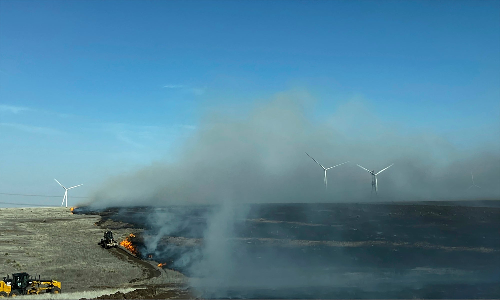En esta imagen proporcionada por el Servicio Forestal de Texas A&M, equipo pesado trabaja para contener el incendio Juliet Pass en el condado de Armstrong, Texas, en  Lunes, 26 de febrero de 2024.