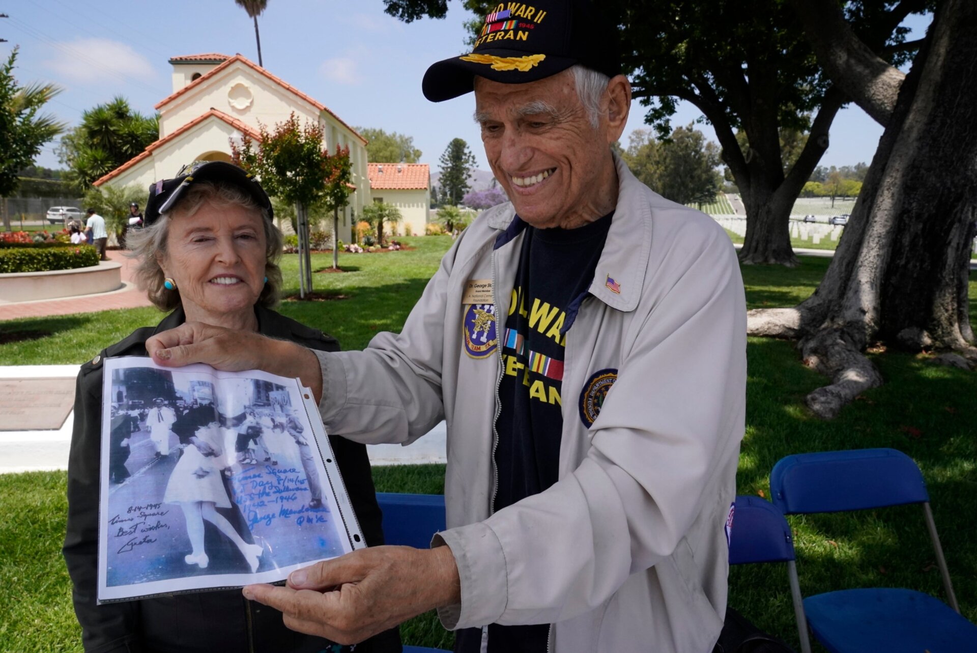 El Dr. George Jack Stanley, veterano del ejército estadounidense de la Segunda Guerra Mundial, con su esposa, Sandra Stanley, miembros del Apoyo al Cementerio Nacional de Los Ángeles   Fundación, bienvenidos a los veteranos al Cementerio Nacional de Los Ángeles, en Los Ángeles, el lunes, 31 de mayo de 2021. Stanley está exhibiendo una copia  del famoso “Día de VJ en Times Square», una fotografía de Alfred Eisenstaedt, autografiada por los personajes de la foto: Greta Zimmer Friedman  y George Mendonsa. 