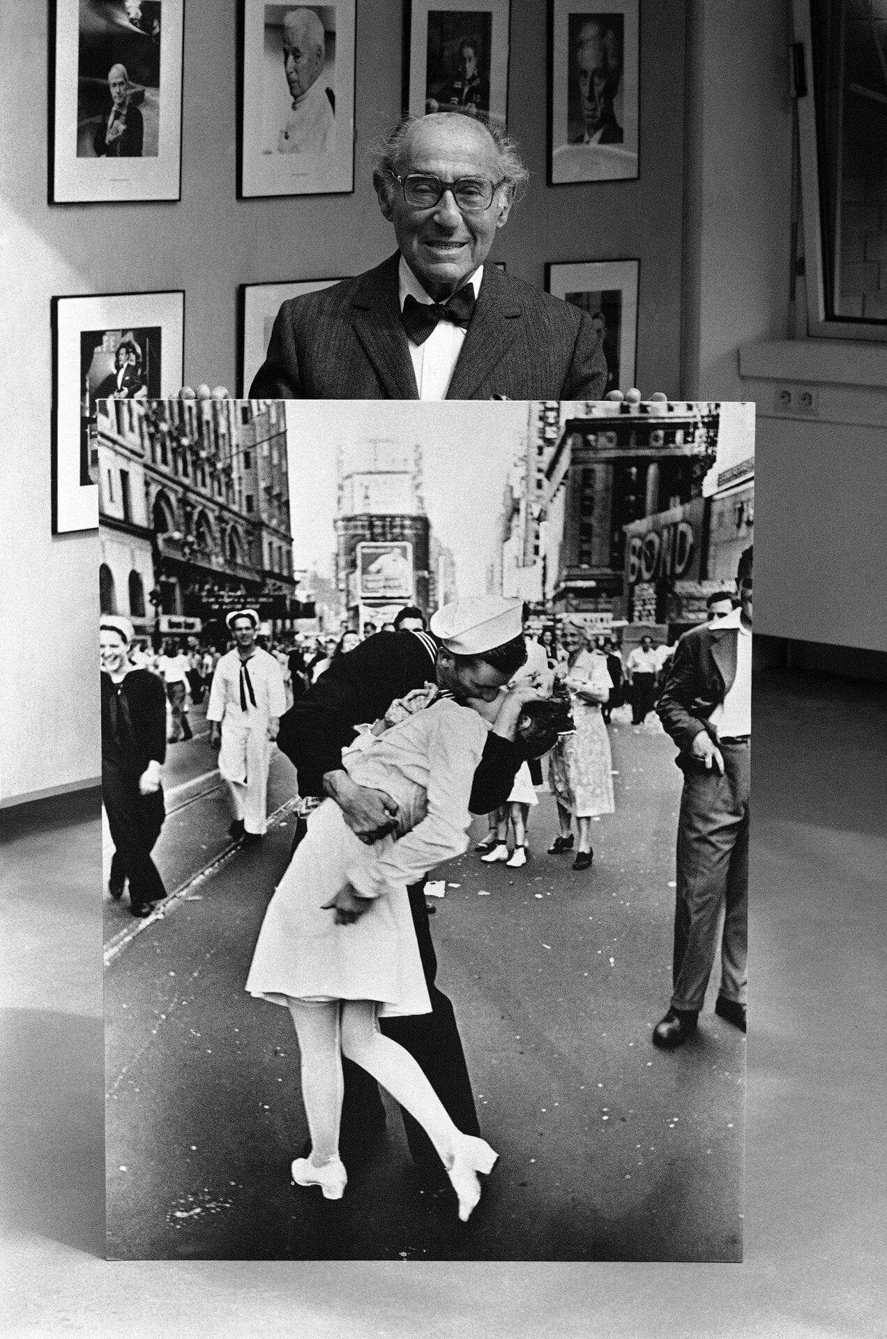 El fotógrafo y fotoperiodista alemán-estadounidense Alfred Eisenstaedt posa en la inauguración, el 5 de mayo de 1986, de una exposición de sus famosas fotografías tomadas para Vida revista en el Kultur Kontor der Hamburger Hanse Vier, en Hamburgo, Alemania, con una de sus fotografías más conocidas, tomada durante la  celebraciones del VJ Day en Times Square, Nueva York, en agosto de 1945. 