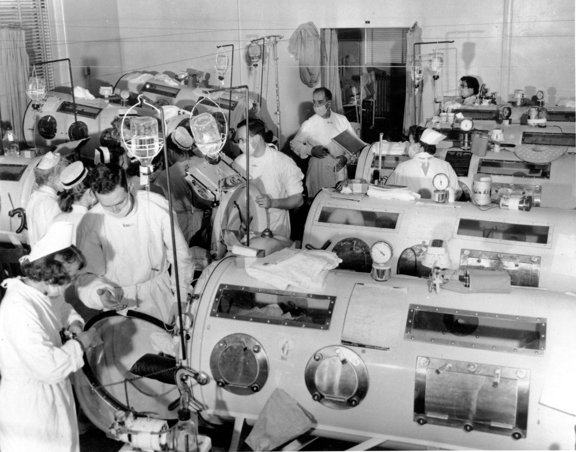 Esta es una escena en la sala de emergencia contra la polio del Haynes Memorial Hospital en Boston, MA, el 16 de agosto de 1955. La epidemia de polio alcanzó un máximo de 480 casos. Los pacientes críticos están alineados muy juntos con respiradores pulmonares de hierro para que Un equipo de médicos y enfermeras puede brindar un tratamiento de emergencia rápido según sea necesario. 