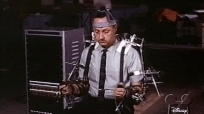 Walt Disney y un ingeniero hacen una demostración de un robot del carrusel del progreso de la atracción de la Feria Mundial de 1964 utilizando un dispositivo de manipulación estilo Waldo. 