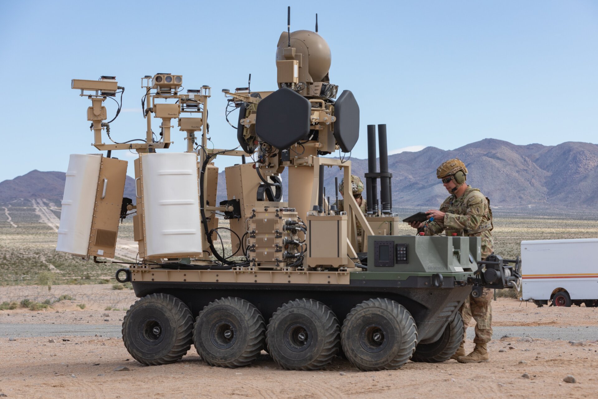 Una plataforma todo terreno, no tripulada, de ocho ruedas, totalmente eléctrica, del Ejército de EE. UU. con un sistema UAS modular contrapequeño con un ser humano en el El sistema operativo de bucle bajo la familia de sistemas no tripulados o FoCUS brinda apoyo a los soldados desmontados en un entorno de entrenamiento urbano como parte.  de un experimento de integración humana en Fort Irwin, California, 18 de marzo de 2024. 