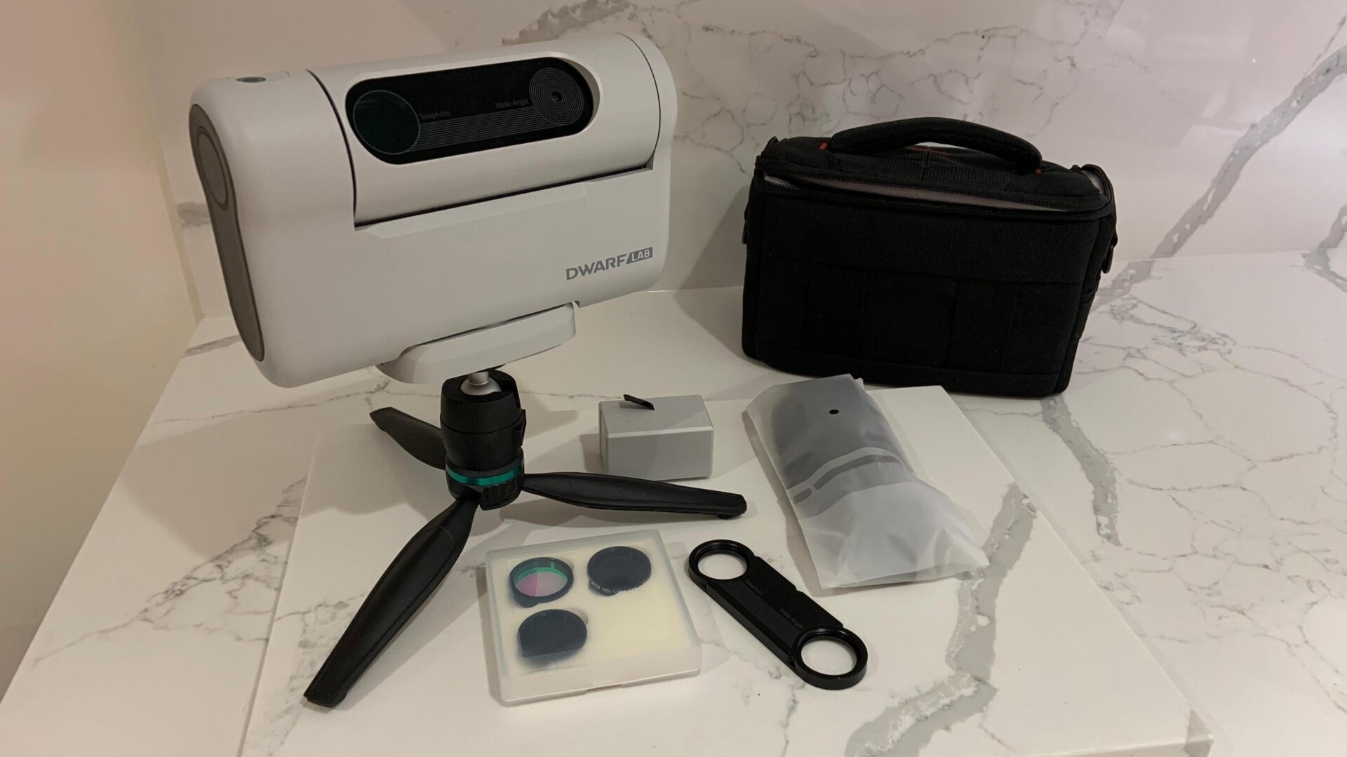 La versión Deluxe viene con una bolsa de transporte negra, una batería recargable, una tarjeta microSD de 64 MB, un mini trípode, una batería adicional y  Filtro para la contaminación lumínica , un par de filtros solares (para combinar las dos lentes ), y el adaptador de filtro.