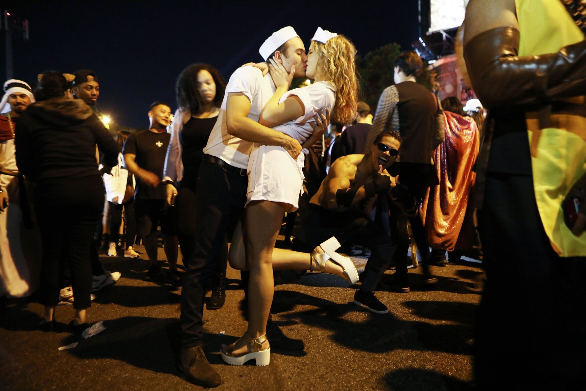 Beso de juerguistas, haciéndose pasar por los sujetos de la famosa foto de beso en Times Square realizada por Alfred Eisenstaedt, en la fiesta callejera anual del Carnaval de Hollywood el 31 de octubre de 2018 en West Hollywood, California.
