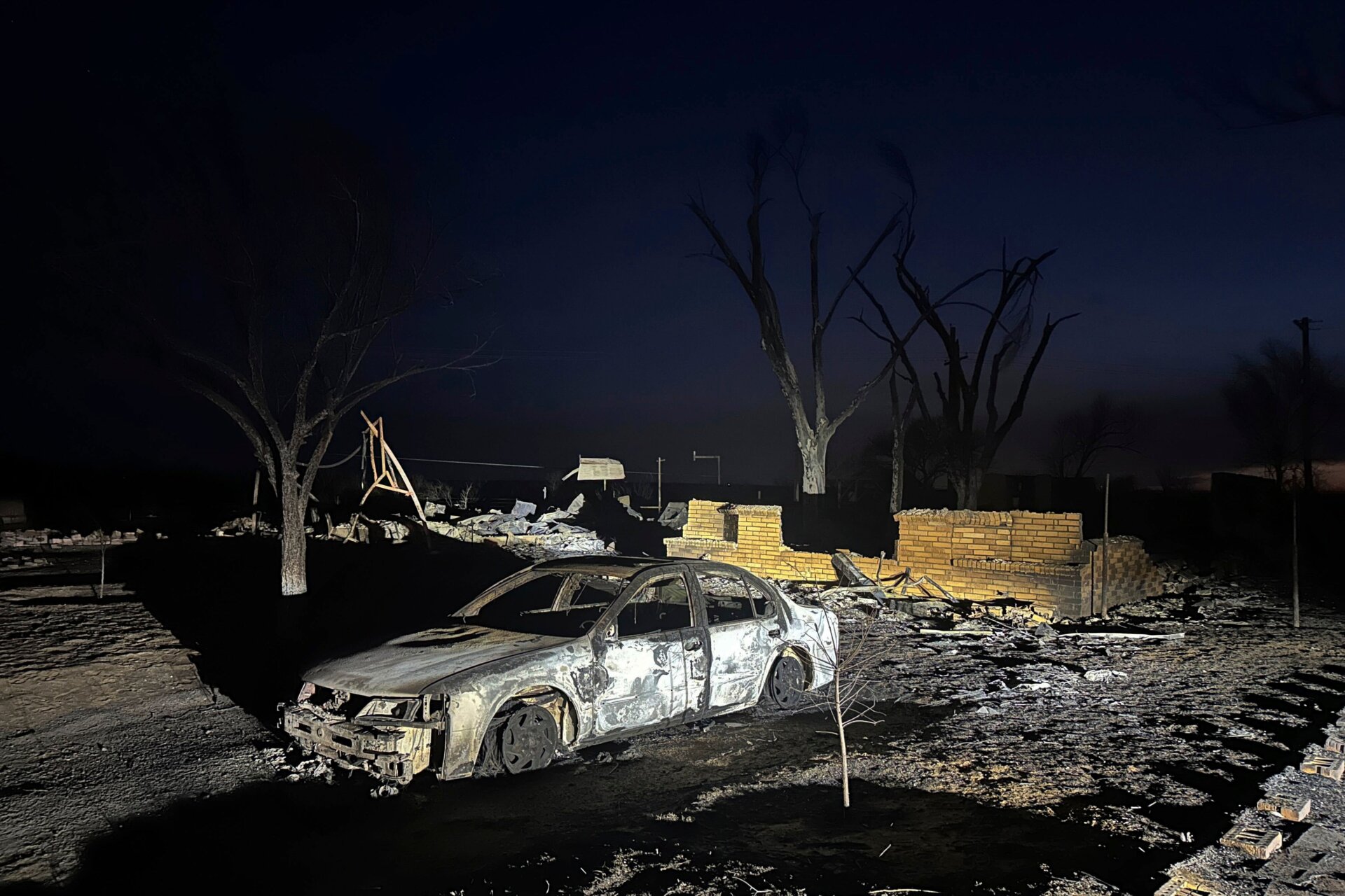 Un vehículo carbonizado se encuentra cerca de las ruinas de una casa después de que la propiedad fuera quemada por el incendio de Smokehouse Creek, el miércoles 28 de febrero.  2024, en  Fritch, Texas.