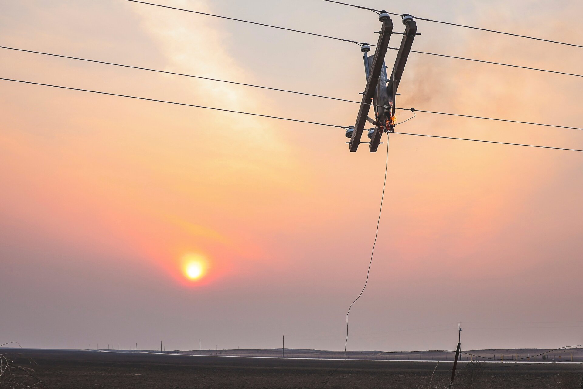 Un poste de teléfono arde debido al incendio de Smokehouse Creek mientras se pone el sol, el miércoles 28 de febrero de 2024 en Canadian, Texas.