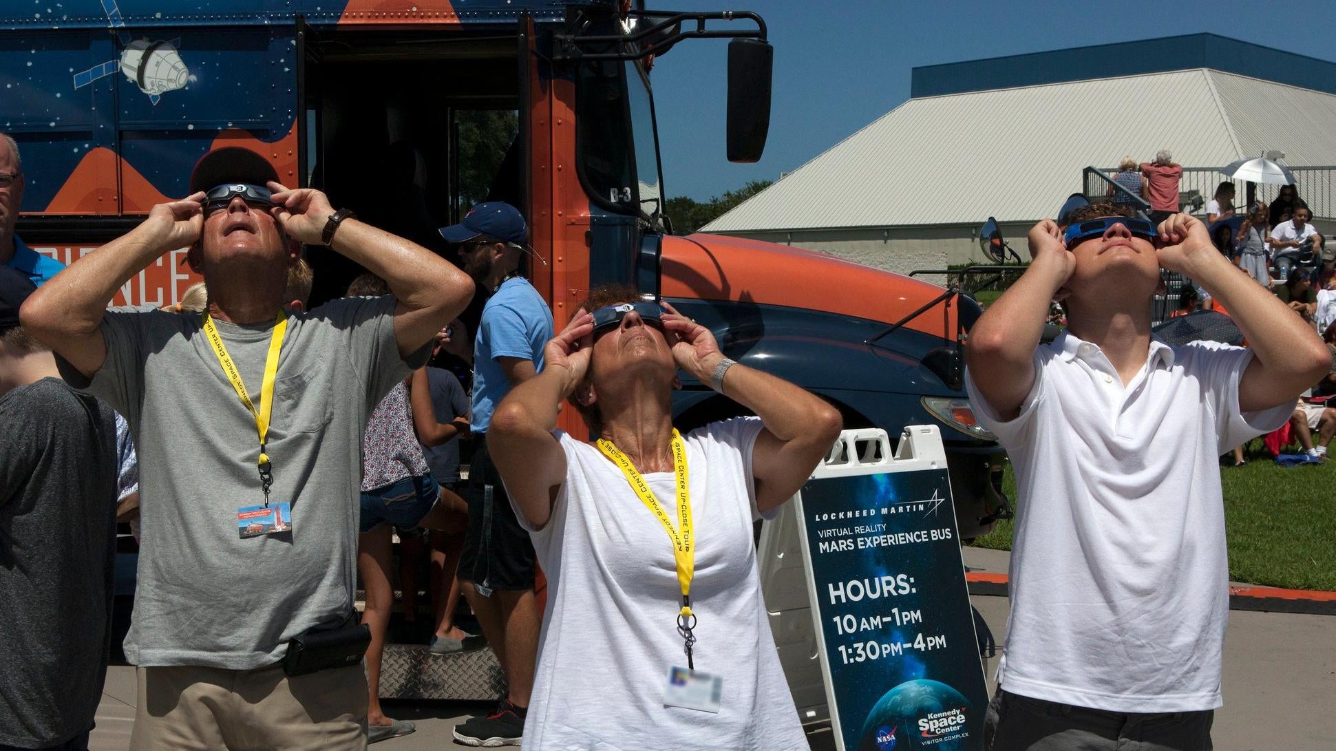 La forma correcta de hacerlo: los visitantes del Centro Espacial Kennedy observan el eclipse a través de lentes de eclipse el 21 de agosto de 2017.
