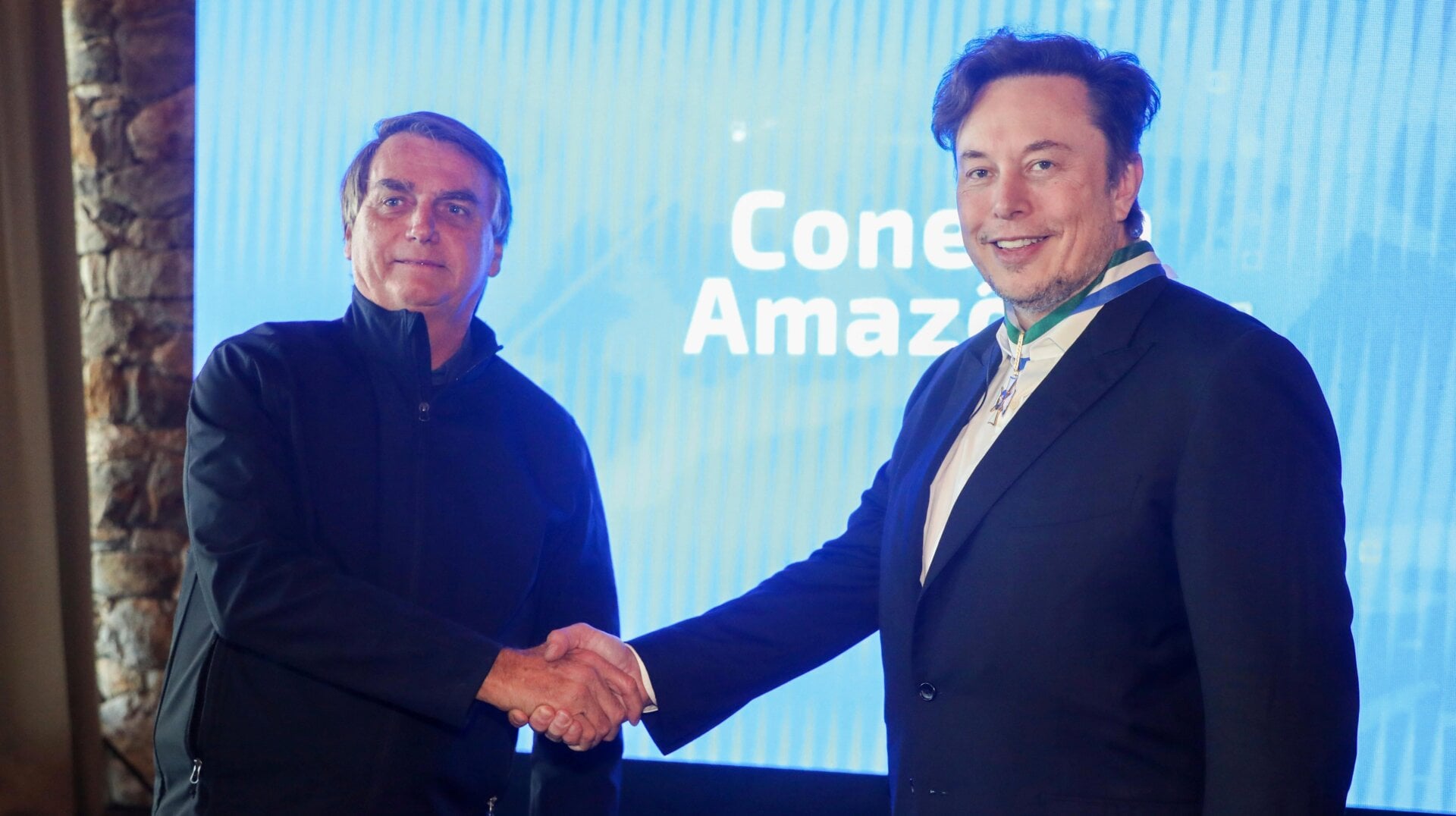 Elon Musk recibe la medalla de la Orden al Mérito de Defensa mientras estrecha la mano del entonces presidente de Brasil, Jair Bolsonaro, en Porto Feliz, Brasil el 20 de mayo de 2022.