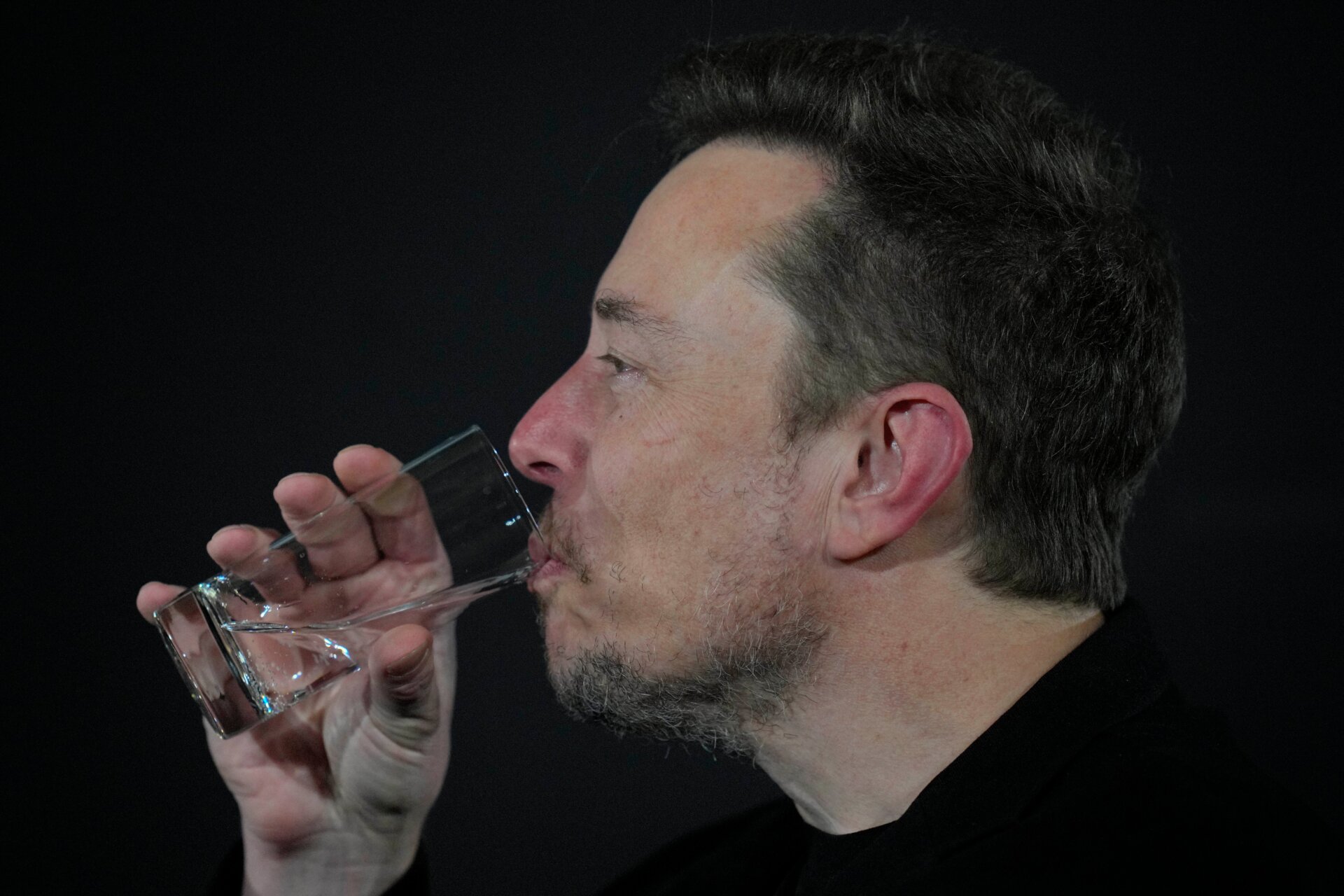 Elon Musk bebe durante un evento de conversación con el primer ministro británico, Rishi Sunak, en Londres, el jueves 2 de noviembre de 2023.